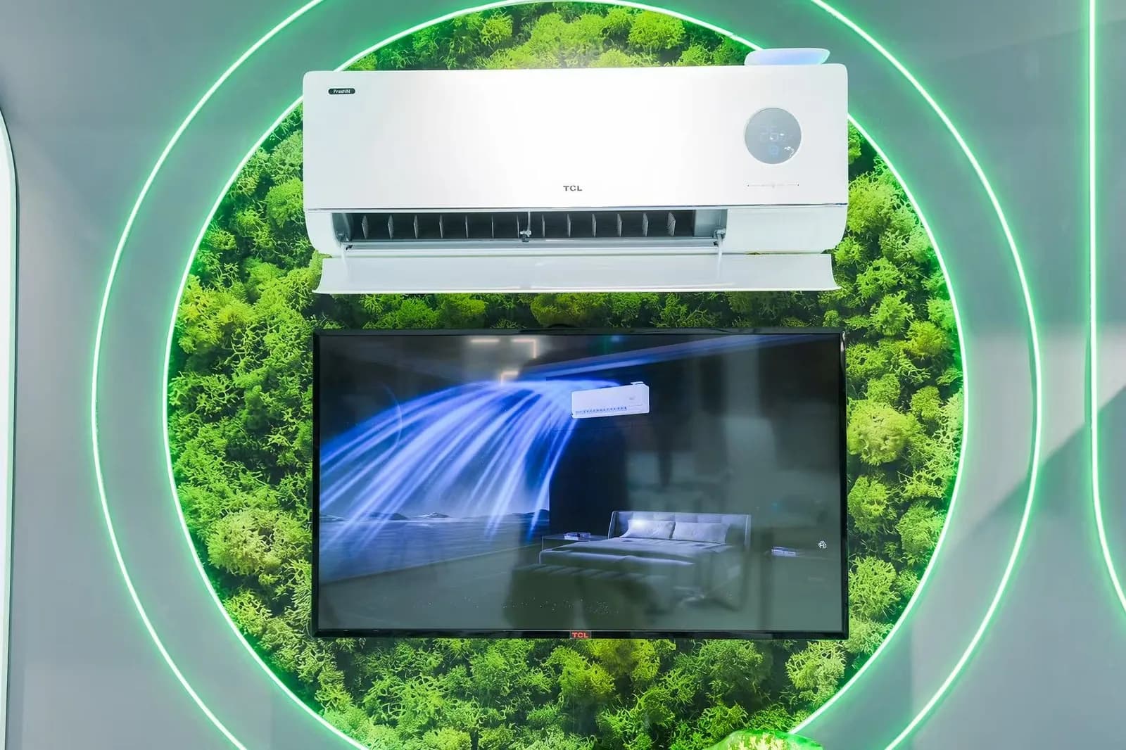 وحدة TCL FreshIN 3.0 الجدارية فوق شاشة تعرض تدفق الهواء، ضمن عرض بالطحلب الأخضر في جناح MCE 2026